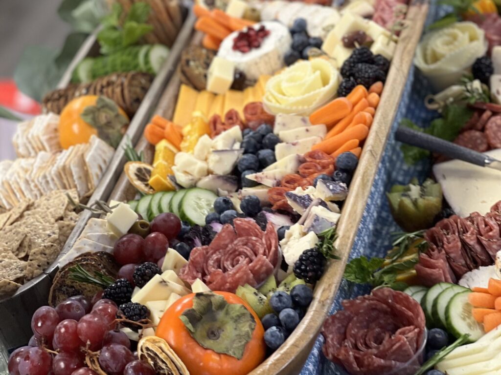 A close-up of the same grazing table, showing a basket in the middle with a great selection of quality ingredients