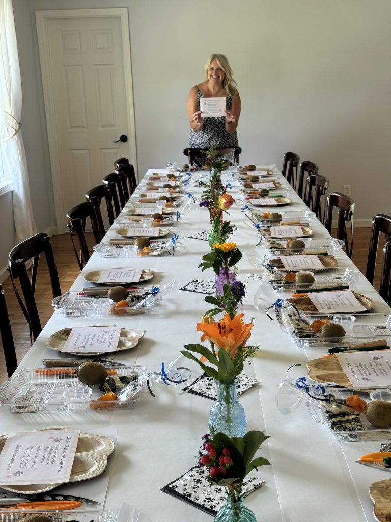 Michelle, standing over t table set and ready for a Team Building Workshop