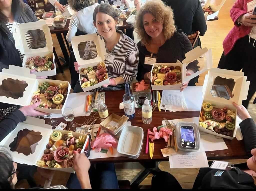 Group of coworkers proudly displaying their finished charcuterie boards.